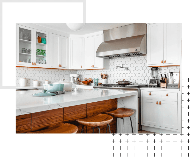 A kitchen with white cabinets and green walls.